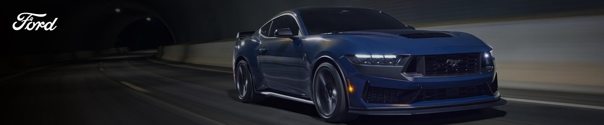 Low angle action shot of a dark blue Ford Mustang driving through a tunnel.